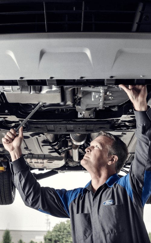 Mechanic working on a car under the lift